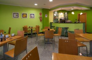 サンシェンショにあるPontus Veterisの緑の壁と木製のテーブルと椅子が備わるレストラン