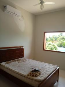 a large bed in a room with a window at Casa da Família - Andar Superior in Nova Viçosa