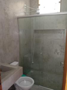 a bathroom with a glass shower and a toilet at Casa da Família - Andar Superior in Nova Viçosa +20 photos