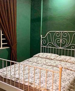 ein Schlafzimmer mit einem Bett mit einer grünen Wand in der Unterkunft Inap Kayangan @ Puncak Alam with Swimming Pool in Bandar Puncak Alam