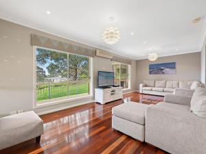 
a living room filled with furniture and a window at Gareth House in Narooma
