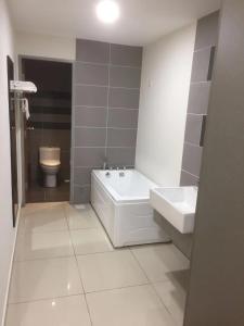uma casa de banho com uma banheira, um lavatório e um WC. em YANGTZE HOME STAY 长江民宿 em Johor Bahru