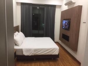 a bedroom with a bed and a television in it at YANGTZE HOME STAY 长江民宿 in Johor Bahru