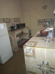 kuchnia z blatem, lodówką i stołem w obiekcie Belretiro Cottage w mieście Bel Retiro