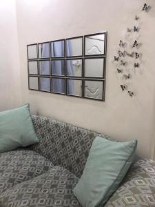 RaRa Homestay Hulu Langat في Kampong Jawa: غرفة نوم مع سرير ومرآة على الحائط
