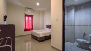 Ένα ή περισσότερα κρεβάτια σε δωμάτιο στο RedDoorz @ Jalan Ratahan Minahasa Tenggara