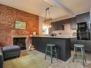 a kitchen with a brick wall and a fireplace at The Bothy in Lytham St Annes