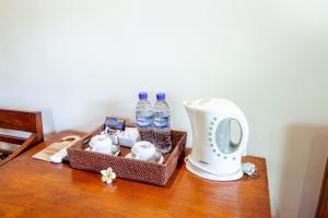 a table with a basket of water bottles and a blender at Lumbung Sari Ubud Hotel in Ubud