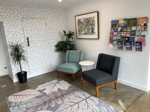 dwa krzesła i stół w pokoju w obiekcie The Osmond Motel & Apartments w mieście Adelaide