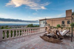 a statue of a lion sitting on a balcony at Casa Vista 6BR Villa, 16p Jacuzzi Pool, Staff & Breakfast in San Miguel de Allende