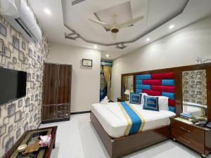 a bedroom with a bed and a flat screen tv at Horizon Hotel in Lahore