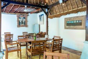a dining room with a wooden table and chairs at Lumbung Sari Ubud Hotel in Ubud