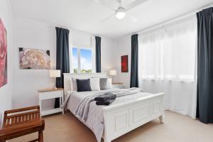 a bedroom with a white bed and a window at Artist's Cottage - Cosy Home in Quiet Leafy Street in Toowoomba