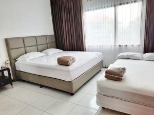 a bedroom with two beds and a window at Vila Batu Bale-Bale in Batu
