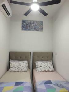 um quarto com 2 camas e uma ventoinha de tecto em The Ridge @ KL East Mall & Condominium em Kuala Lumpur