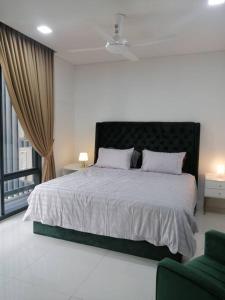 um quarto com uma cama grande e uma cadeira verde em The Ridge @ KL East Mall & Condominium em Kuala Lumpur