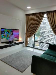 a living room with a green couch and a flat screen tv at The Ridge @ KL East Mall & Condominium in Kuala Lumpur