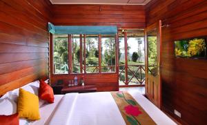 a bedroom with a bed in a room with windows at Dream Catcher Plantation Resort in Munnar +75 photos