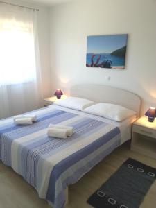 1 dormitorio con 1 cama grande y 2 almohadas blancas en Apartments Levanat, en Zadar