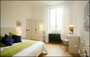 a bedroom with a bed and a desk and a window at La Maison Rouge d'Uzes B&B in Uzès +131 photos