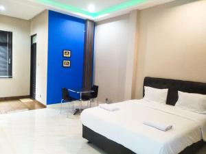 - une chambre avec un lit et un mur bleu dans l'établissement Mandabelle Villa 1 room, à Citeureup