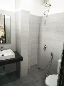 La salle de bains est pourvue d'un lavabo, de toilettes et d'une douche. dans l'établissement Mandabelle Villa 1 room, à Citeureup