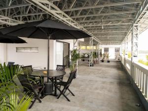 a patio with a table and chairs and an umbrella at Mandabelle Villa 1 room in Citeureup