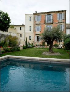 an empty swimming pool in front of a building at La Maison Rouge d'Uzes B&B in Uzès
