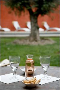 einen Tisch mit zwei Weingläsern und einem Teller Cracker in der Unterkunft La Maison Rouge d'Uzes B&B in Uzès