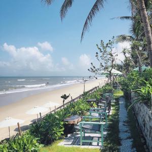 una fila de mesas y sombrillas en una playa en Tan Thanh Garden Homestay, en Hoi An