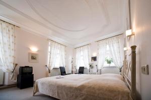 海德堡的住宿－高登赫克特酒店，一间卧室配有一张大床和两把椅子