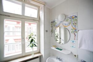 ハイデルベルクにあるホテル ゴールドナー ヘヒトのバスルーム(洗面台、鏡、窓付)
