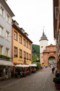 a street with buildings and a lighthouse in a town at Hotel Goldener Hecht in Heidelberg