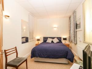 a bedroom with a bed and a chair at Palace Apartment Main Street in Grange Over Sands