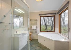 a bathroom with a tub and a sink and a window at Absinthe in Dinner Plain +8 photos