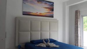 a bedroom with a blue bed with a painting on the wall at Villa Emita Trou aux Biches Beach Appartement in Trou aux Biches