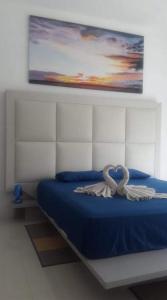 ein Schlafzimmer mit einem blauen Bett mit einer Schleife darauf in der Unterkunft Villa Emita Trou aux Biches Beach Appartement in Trou aux Biches