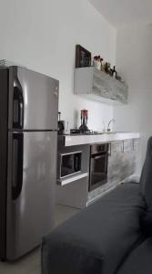 een keuken met een roestvrijstalen koelkast naast een bank bij Villa Emita Trou aux Biches Beach Appartement in Trou aux Biches