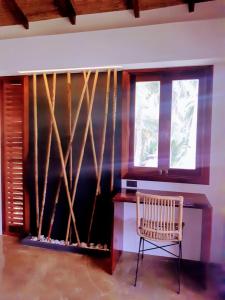 ゼネラル・ルナにあるLagkaw Siargao Villasの暖炉、椅子、窓が備わる客室です。