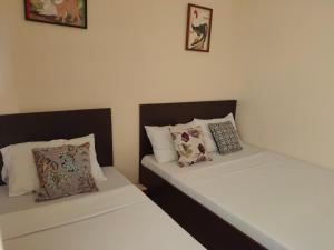 two beds in a room with white sheets and pillows at Fiesta Ballroom Hotel in Legazpi +18 photos