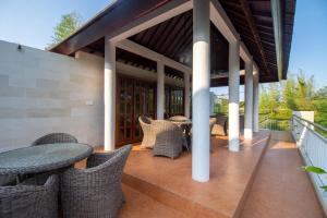un patio al aire libre con sillas de mimbre y una mesa en Villa Sayang Sanur III, en Sanur