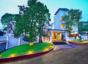 une maison avec un arbre en face dans l'établissement Amoravida By 7 Apple Resorts, Goa, à Mandrem