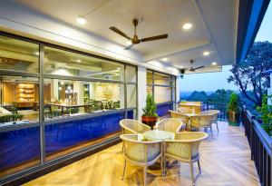 a patio with tables and chairs on a balcony at Amoravida By 7 Apple Resorts, Goa in Mandrem