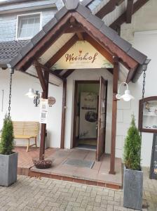 Hotel Weinhof Groß Mackenstedt في ستوهر: مظلة على مدخل مطعم مع مقعد