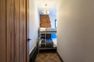 Mały pokój z łóżkiem piętrowym i ceglaną ścianą w obiekcie The Secret Cottage - Morpeth w mieście Morpeth
