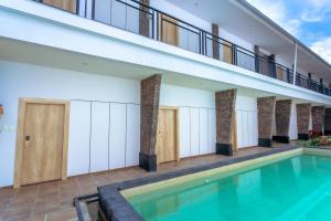 a swimming pool in a building with a balcony at Lega Legi Town House Seminyak by The Lavana in Seminyak