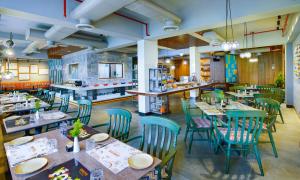 a restaurant with tables and chairs in a room at Amoravida By 7 Apple Resorts, Goa in Mandrem