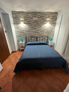 a bed in a room with a brick wall at B&B San Domenico in Realmonte