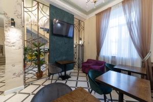 un restaurante con mesas, sillas y TV en Park Hotel, en Severodvinsk