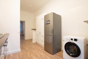 a kitchen with a refrigerator and a washing machine at RAJ Living - 1 or 3 Room Apartments - 20 Min Messe DUS and Old Town DUS in Düsseldorf